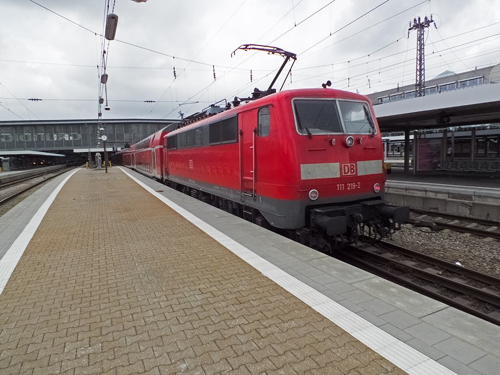111 219 erreicht am 29.07.14 mit einem aus Doppelstockwagen der ersten gesamtdeutschen Generation gebildeten Zug den Münchner Hauptbahnhof.