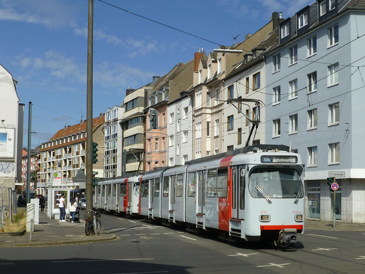 Die Wagen 3228 und 3218 (hinten) der Rheinbahn auf der U75 Richtung Vennhauser Allee. Hier, an der Haltestelle  Am Hackenbruch , gibt es allerdings keine Infrastruktur, die dafür spricht, dass es sich um eine U-Bahn oder Stadtbahn handelt.