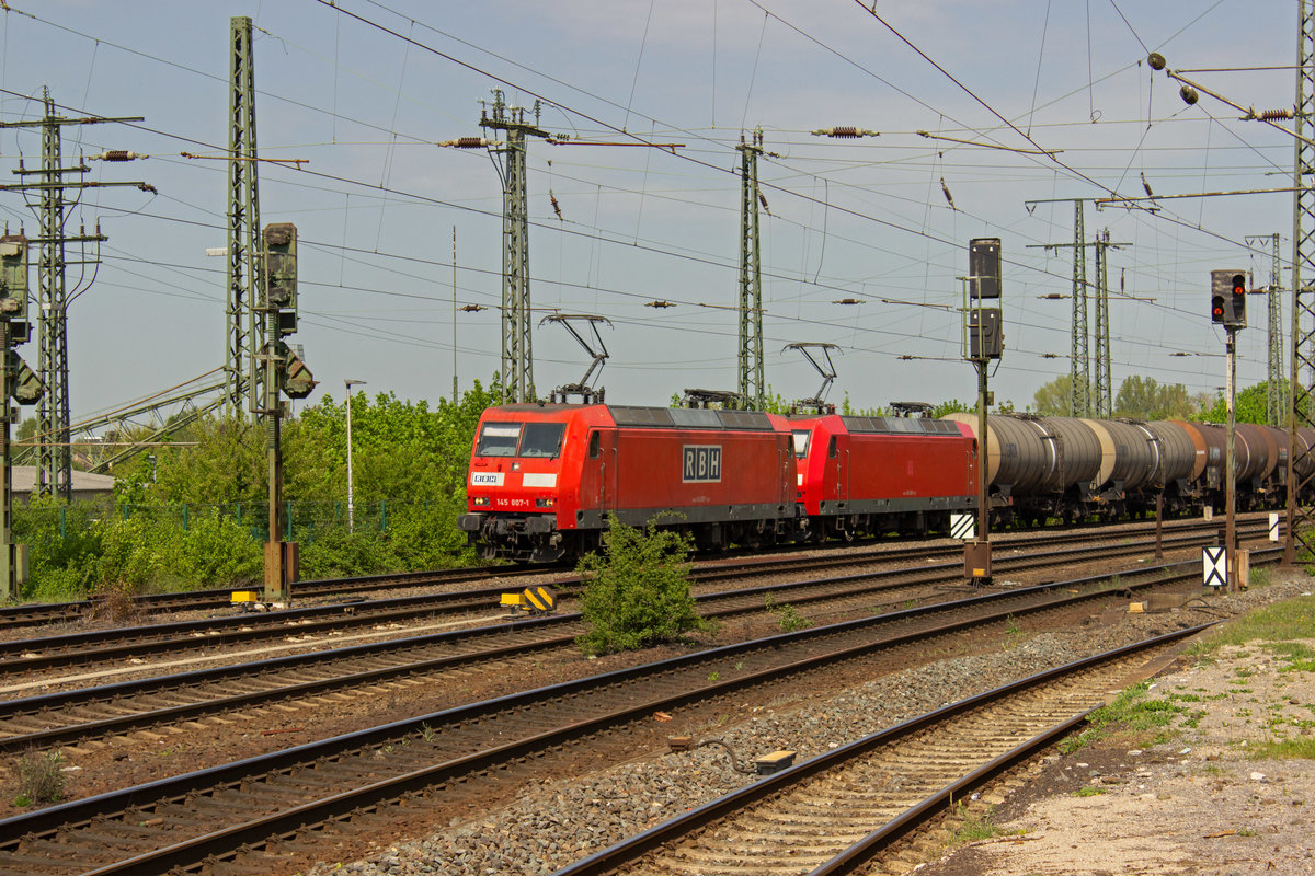 145 007 und 026 gehren zu den von DB Cargo an RBH vermieteten Lokomotiven dieser Baureihe, die dort die ebenfalls ehemaligen DB-Loks der Baureihe 143 ablsen. Am 24.04.19 durchfahren beide gemeinsam den Bahnhof von Hamm, wobei nur 145 007 bereits als RBH-Lok zu identifizieren ist.