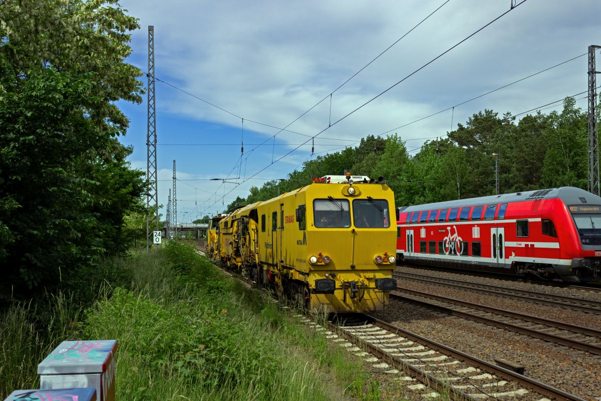 Eine Matisa-Stopfmaschine der Firma Strabag ist zur berholung durch Fernverkehrszge auf das Ausweichgleis im Bahnhof Ludwigsfelde geleitet worden und rollt nun auf das Ausfahrsignal zu. Die Besatzung freute sich offensichtlich ber die Aufmerksamkeit des Fotografen und grte mit ausgiebiger Nutzung des Makrophons.