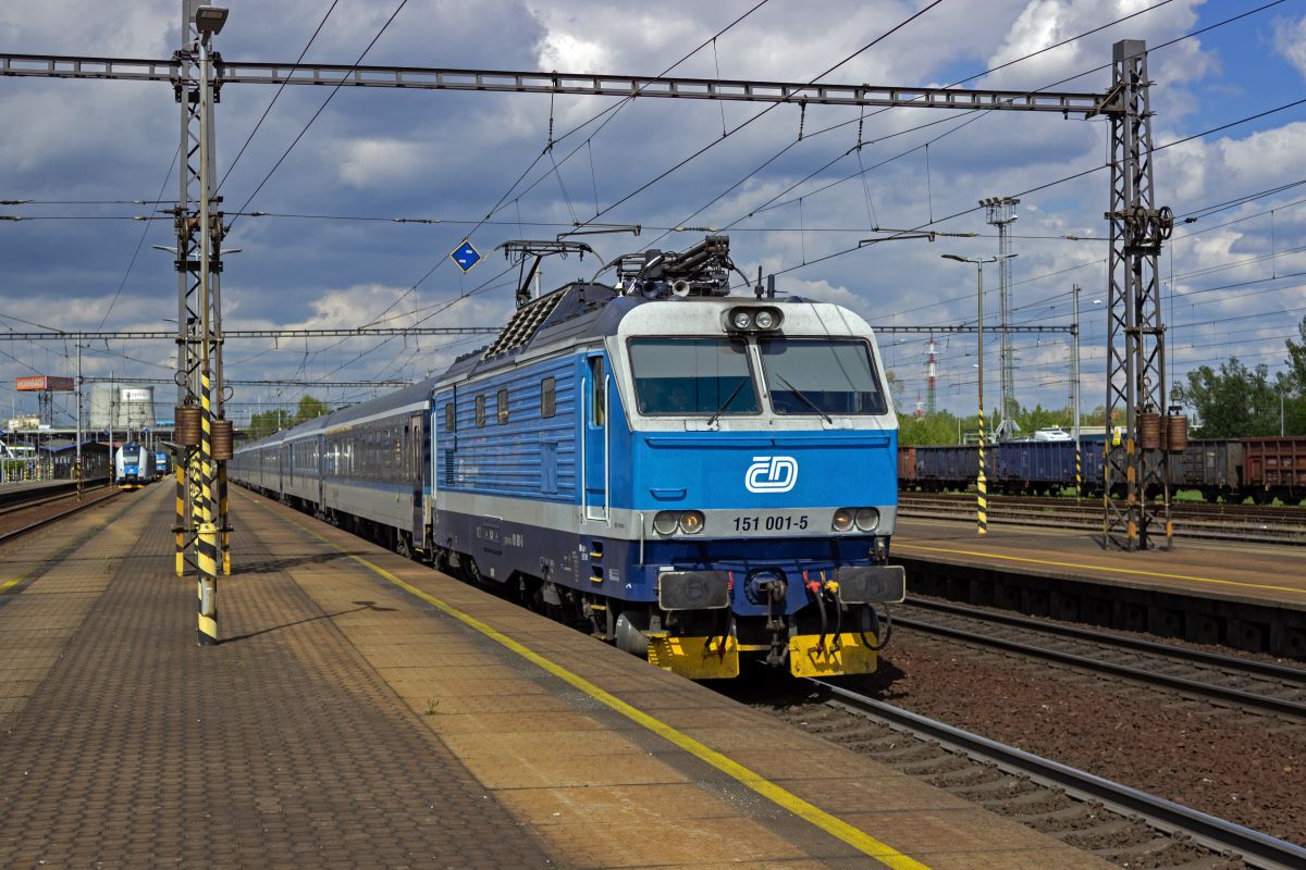 Im ersten Halbjahr 2024 war der aus Przemyśl kommende IC 114 zwischen Bohumin und Praha noch eine Planleistung der Baureihe 151, die seither nicht nur diese, sondern alle regul�ren Zugleistungen verloren hat. Am 25.04.24 war 151 001 f�r die Traktion eingeteilt. Bei der Ausfahrt in Ostrava-Svinov ist der hohe Aufbau f�r die L�fter in der Dachschr�ge dieser Hochleistungslokomotiven gut zu erkennen.