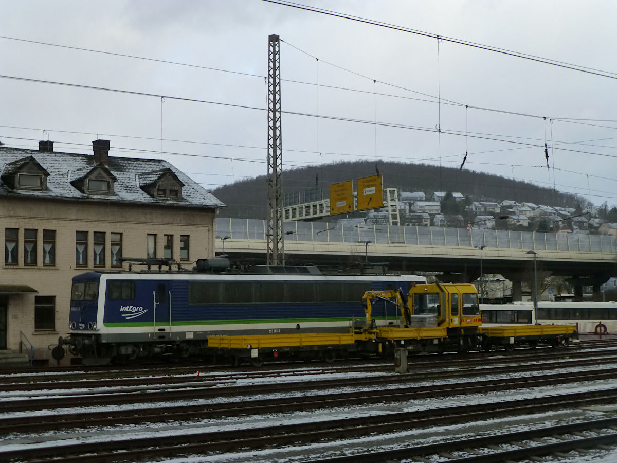 Im Schneeregen des Siegener Vorfrühlings stehen am 12.2.2020 diese Fahrzeuge genau gegenüber der Bahnsteige am Hauptbahnhof: Ein Gleiskraftwagen Typ SKL der KAF Falkenhahn, dahiner die 155 045 von IntEgro.