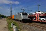 Whrend ein Autotransportzug auf dem Durchfahrtsgleis in Saarmund einen Zwischenstopp einlegt, berholt die Railpool-Lokomotive 186 433 mit einem Containerzug ber das Bahnsteiggleis.