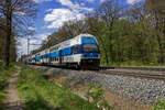 Im Schatten der B�ume, die an diesem 26.04.2024 erst langsam Bl�tter bekommen, rollen 471 073 und ein weiterer CityElefant dem n�chsten Halt in Praha-Kl�novice zast. entgegen.